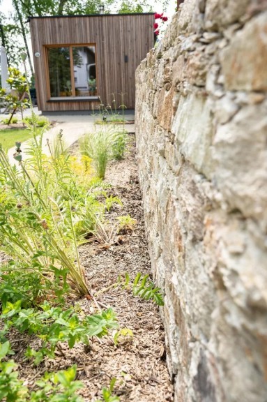 Stauden Holzfassade Steinmauer privat Garten G
